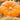 Giant orange pumpkin laying in a pile of hay.