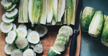 Peeled, sliced, and chopped garden cucumbers on a cutting board.