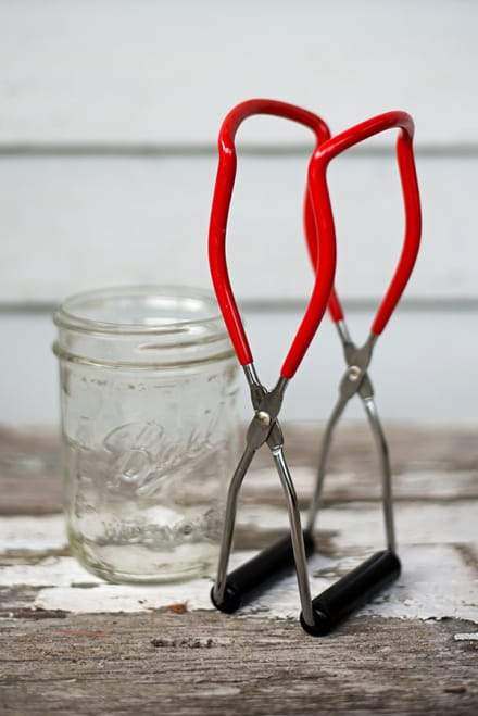 Bright red jar lifter with black rubber tips.