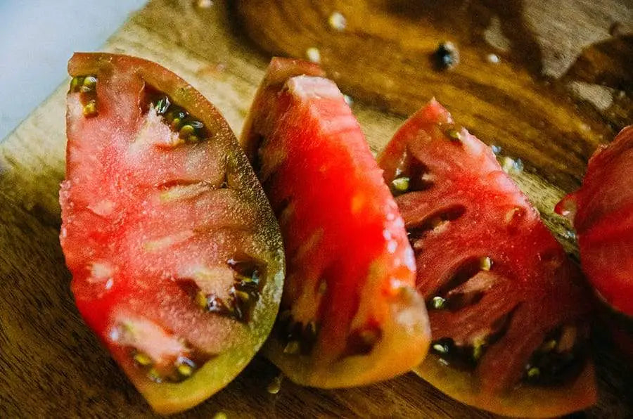 An heirloom green and red garden tomato sliced open.