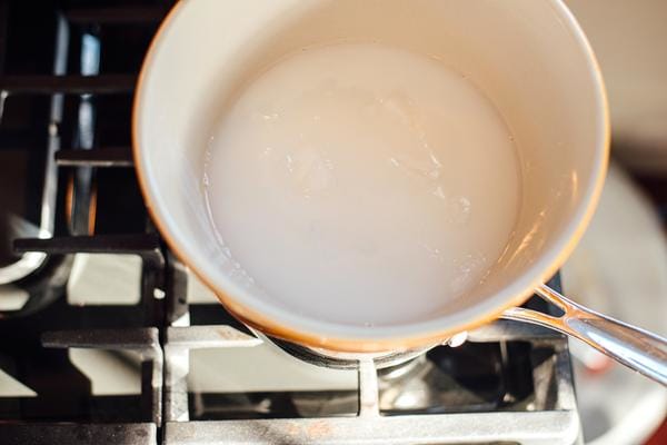 Soap melting in a yellow pan on a stove top.